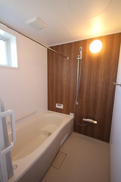 木目調のアクセントパネルが印象的なバスルーム。機能的で温かみのある空間が、日々の疲れを癒してくれる