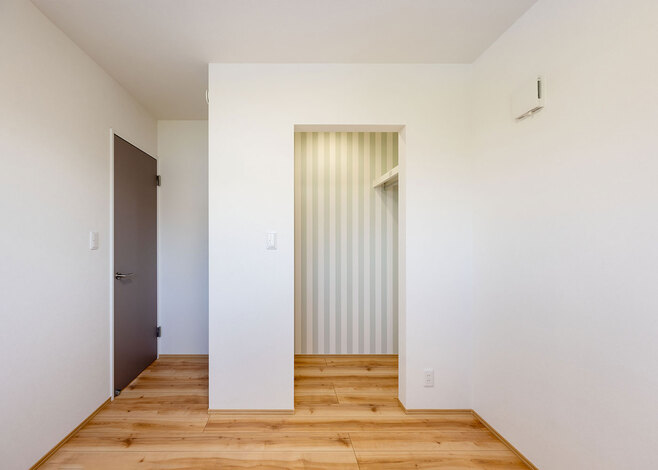 2階の子ども部屋。クローゼットは扉をつけずオープンな仕様に。ストライプのクロスがアクセント
