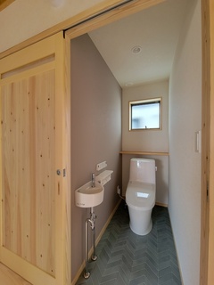 手洗い器付きでコンパクトながら機能性抜群。節水型トイレを採用し、来客も使いやすい清潔感あふれるパウダールーム。【アクトホーム】