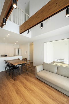 ナチュラルな木の温もりが感じられるリビングダイニング。吹き抜けの天井と大きな窓が開放感を演出。