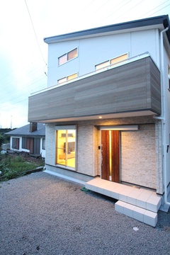 モダンなデザインの二階建て住宅の外観。木材と白い壁面のバランスが調和し、シンプルで洗練された印象を与える。【小野田産業～designers house project～】