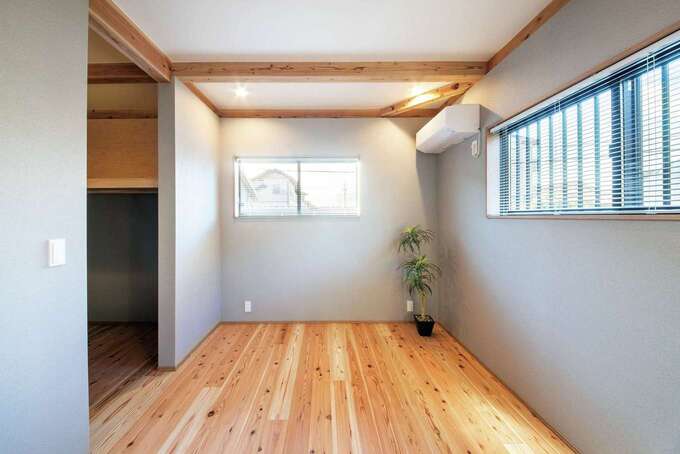 スギの床の木目が美しい寝室は、ウォークインクローゼット付き。2方向に窓を設け明るさを確保