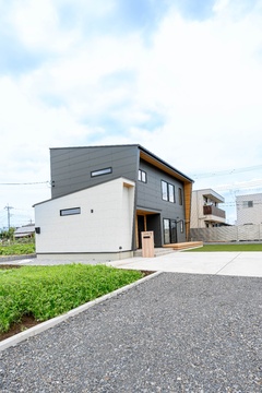 モダンで洗練されたデザインの住宅外観。異なる素材を組み合わせたファサードが目を引き、周囲の風景と調和している。【タカオ設計】