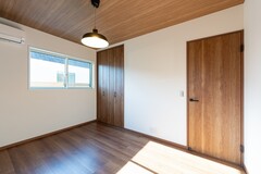 天井と床に木目調の仕上げを施した、ナチュラルで落ち着きのある洋室。
木目のトーンを統一することで、シンプルながらも上質な印象に。【丸宗建設】