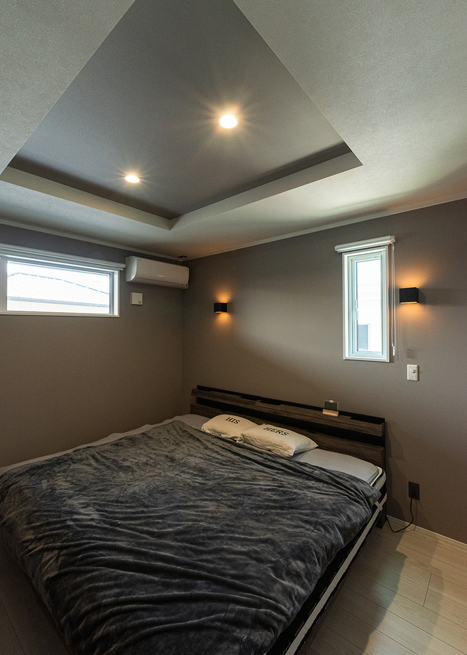 クロスや照明で明るさのトーンを落とし、折り上げ天井にした寝室。ホテルのような上質感が漂う