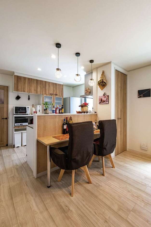 夫婦二人なので、食事はキッチンカウンターで。ダイニングテーブルを置かない分、リビングを広く使えるようになった。床はペットの足腰にやさしい専用のフローリングを採用