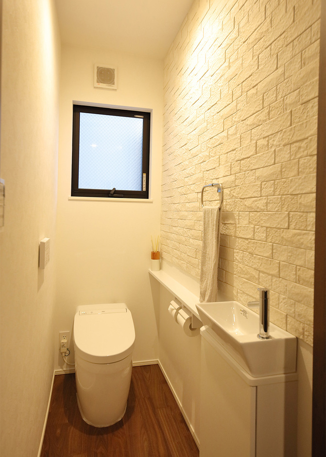 一階トイレは一畳のスペースにコンパクトな手洗いを設けた。タンクレストイレを採用し、よりスタイリッシュな空間に。壁面にはエコカラットを貼り、脱臭機能も
