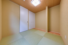 落ち着いた色合いの畳とシンプルなデザインの壁が特徴的な和室。シーリングライトが柔らかい光を提供し、穏やかな空間を演出している。【R＋house御殿場（岳南建設）】