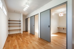 明るい木目の床と白い壁が特徴の居室。大きな収納棚があり、小物から書類まで整理整頓がしやすい。引き戸でプライバシーも確保可能。【ハレノイエ （中村土建）】