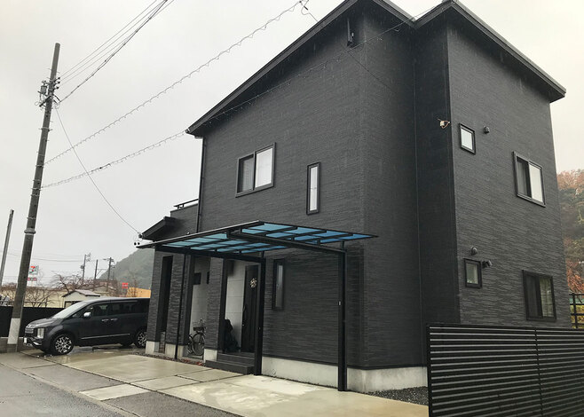 ブラックで仕上げた存在感のある外観。片流れの屋根には太陽光発電パネルを搭載している