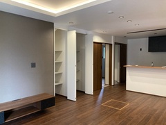 落ち着いたトーンのフローリングとシンプルな内装が調和したLDK。オープンキッチンが空間を広く見せ、生活の中心となる心地よいスペースを演出している。