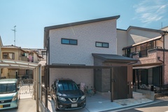 シンプルで現代的な二階建て住宅の外観。落ち着いた配色とクリーンなラインが、街並みに溶け込んでいる。【新栄建設】