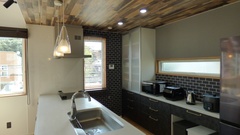 黒いタイル柄のクロスなど、ダークトーンでまとめられたキッチン。お子さまの様子を見ながら料理ができるのが◎。