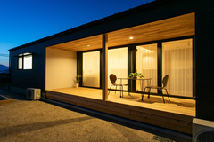 落ち着いた雰囲気のテラス。夜におしゃれなライトアップが施され、リラックスできる空間となっている。簡素だが洗練されたデザインが特徴。