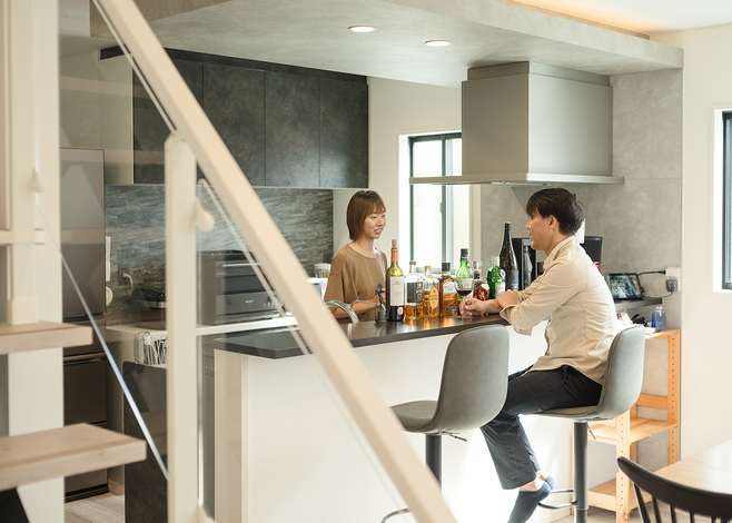 ご主人念願のバーカウンターで過ごすひとときは至福の時間。モノトーンでシックにまとめた。左手のパントリーはサイズも使い勝手も大満足