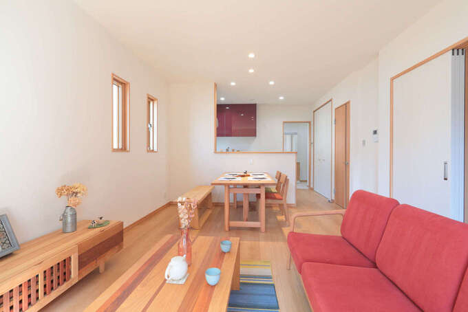 親世帯のLDKは16畳。赤いソファが挿し色に。テレビボードは造作