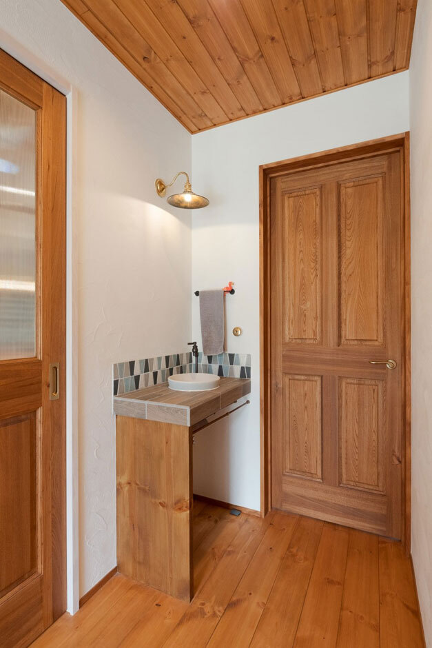 玄関ホールに設けられたミニ手洗いは、衛生面で機能性が高い。ブルーのタイルがかわいいアクセントに