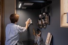 落ち着いたトーンのクリーンなキッチン。調理器具が壁面に整然と収納されており、使いやすさと美しさを兼ね備えている。【アクトホーム】