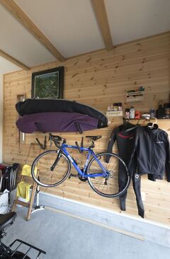 サーフボードや自転車など、ご主人のスポーツギアを収納するガレージ。壁に無垢板を貼り、ワイルドな中にもやさしい雰囲気に仕上げた