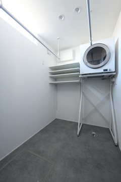 収納棚と洗濯機を備えたランドリールーム。余裕あるスペースで効率的な家事が行えるよう工夫されている。【REIWA HOUSE（令和ハウス）】