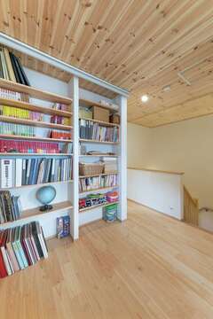 2階ホールの造作書棚には、ご主人が好きなミステリー作家の文庫本小説が全巻そろう。上部に取り付けたスクリーンを降ろすと、一瞬にしてホームシアターに早替わりする【芹工務店】