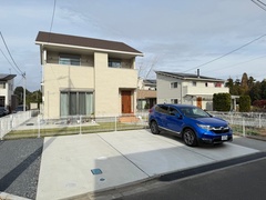 モダンな二階建て住宅の外観。広々とした駐車スペースと整った庭が魅力的で、落ち着いた住宅街に位置する。【サンアイホーム】