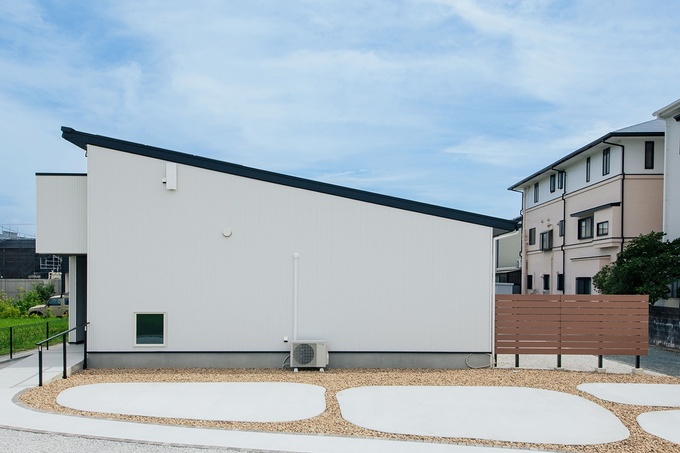 シンプルなデザインに白いガルバリウムが映える。なだらかなスロープが玄関まで続き、自転車を収納するのに便利だ。「外構屋さんにお願いして、実家の庭にあったモッコウバラを植えてもらいました」そう笑うKさん。思い出の花が咲く日を心待ちにしている