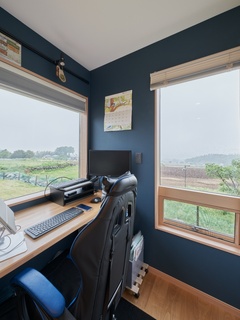 窓からの景色を楽しみながら作業できる書斎。落ち着いたブルーの壁が集中力を高め、快適な作業環境を提供する空間である
