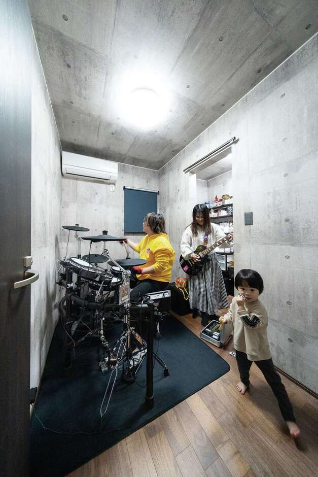 バンド活動で知り合ったI夫妻が熱望した空間。完全な防音室は費用が大きくなりすぎるため、間取りに工夫し、防音効果をもつ断熱材で部屋全体を包むことで、気兼ねなく演奏を楽しめる空間が完成。奥はご主人のコレクションルームで、趣味のグッズが並ぶ