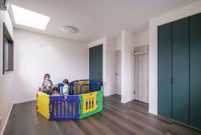 双子の男の子専用の子ども部屋。まだ小さいうちは3姉弟が一緒に遊べるようワンルームとして使い、必要に応じて間仕切りすることも。飽きのこないよう、建具もシックな色でコーディネートした。天窓から柔らかな光が降り注ぐ気持ちいい空間