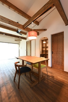 天井の梁が印象的なダイニング。木製のテーブルとカラフルな椅子がアクセントとなり、温かみのある空間を演出している。【REIWA HOUSE（令和ハウス）】