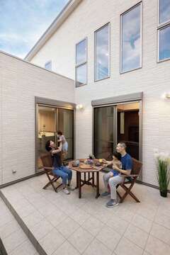 建物をコの字型の囲んだことによって生まれた中庭のテラス。隣家に見られることなく、BBQや子どもプールを楽しむことができる。広いタイルデッキは掃除もラクラク