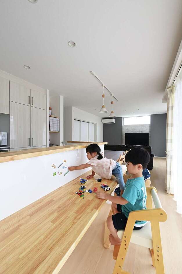 キッチン前にホワイトボードとカウンターを設け、子どもたちのスタディコーナーにした。明るく過ごしやすいため、ご主人がワークスペースとして使うことも多いそう