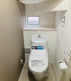 コンパクトで機能的なトイレ空間。窓の配置により換気も良く、自然光が差し込む明るい雰囲気。デザイン性と実用性を兼ね備えている。【沢田建設】