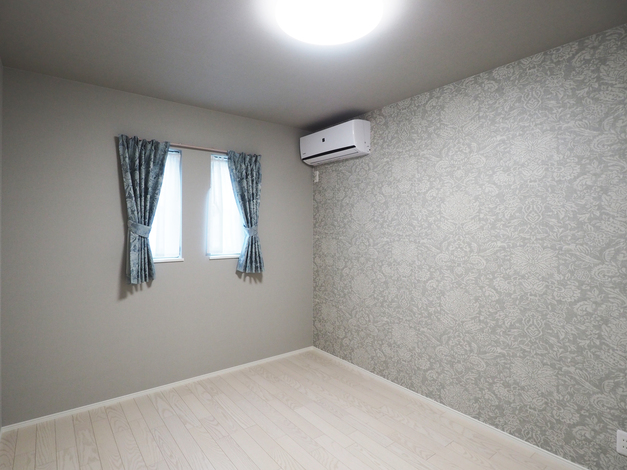 主寝室も同系色の花柄のクロスをアクセントに使用し、上品で落ち着いた空間に