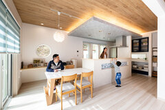 白と青の色調がさわやかなダイニング・キッチン。キッチン上部の下がり天井と間接照明が引き立つ