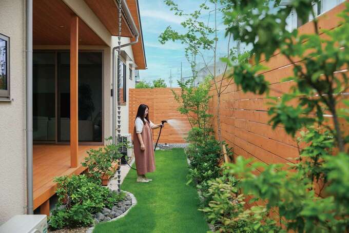 庭は季節ごとに色づく木々や花々を楽しめるよう計画。ウッドデッキを通して、四季折々の眺めと豊かさが室内へと運ばれる。屋根から雨水が伝わって流れていく鎖樋（くさりとい）は、ご主人の希望で採用。流れる水の動きが面白く、雨の日はつい眺めてしまう
