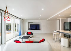 こだわりのプライベートガーデンとひと続きになる大開口のLDK。テレビ側の壁面はすべて収納に。鉄骨造のような大空間とするため、柱の位置にも工夫がある