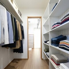 整然としたウォークインクローゼット。衣類が美しく収納され、奥にはランドリールームと直接つながり、生活動線が確保されている。【木の花ホーム】