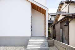 パッと目を惹く可愛らしい三角屋根に、ぐるっと施したレッドシダーがアクセントとなっています。前面はホワイトの塗り壁、2階部分と側面はホワイトのガルバリウムと、同色異素材の組み合わせもポイントです。【ひだまり工房】