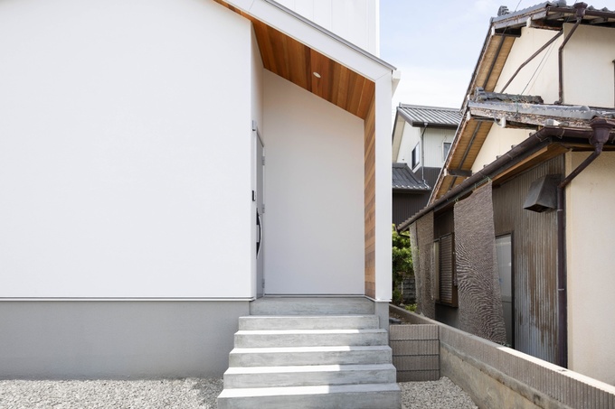 パッと目を惹く可愛らしい三角屋根に、ぐるっと施したレッドシダーがアクセントとなっています。前面はホワイトの塗り壁、2階部分と側面はホワイトのガルバリウムと、同色異素材の組み合わせもポイントです。