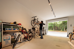 収納力抜群のガレージ。自転車や工具が整然と収納されており、作業スペースとしても利用可能な広さである。【木粋舎 一級建築士事務所】
