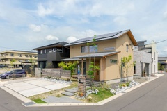 住宅街の角地に佇み、塗り壁の外壁に植栽の緑が映え、印象的なお住まいになりました。