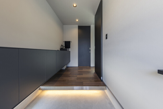 シンプルでスタイリッシュな玄関ホール。間接照明が足元を優しく照らし、清潔感とモダンさが際立つデザインとなっている。
