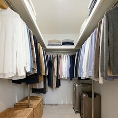 洋服が整然と並ぶウォークインクローゼット。収納力抜群で、スーツケースやバスケットも収納可能。