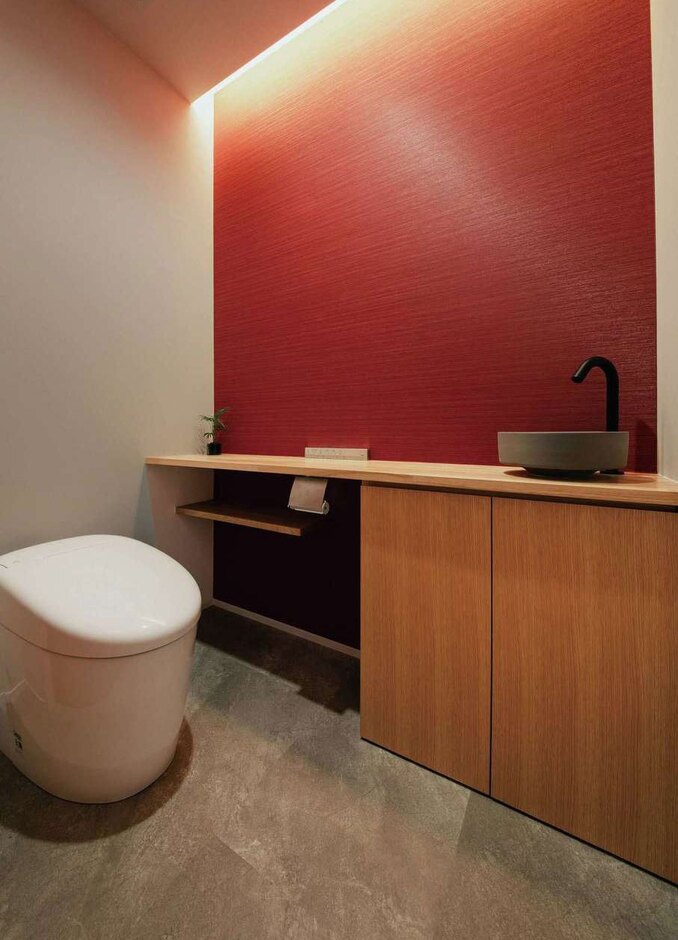 造作カウンターから水栓、間接照明などまで、気に入ったデザインのトイレの画像を渡してイメージに近づけてもらった。アクセントウォールは、奥さまの好きな赤色に。和室の吊り押し入れの下部にも、この赤色が使われている
