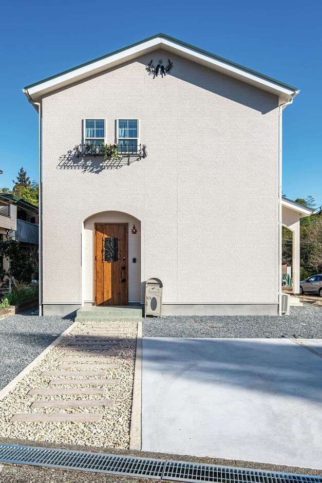 「三角屋根のかわいいお家」に憧れていた奥さまの夢が実現。アーチの垂れ壁、アイアンのフラワーBOX、妻飾りがバランス良く融合した家は、静かな森の中の一軒家のような雰囲気をまとう