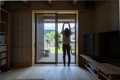 大きな窓から庭が見渡せる明るいリビング。木の温もりを感じられるフローリングと天井が、自然と調和する。【アクトホーム】