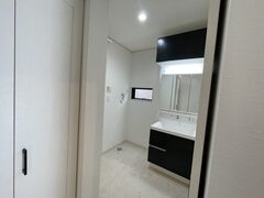 モダンなデザインの洗面スペース。シンプルで機能的なキャビネットが、日常の使い勝手を考慮し配置されている。σ計的な空間演出が魅力的。【タムラ建築設計】