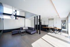 大きな窓からの自然光が入り込み、明るい雰囲気を演出。モダンな家具とインテリアが調和し、快適な空間が広がります。
